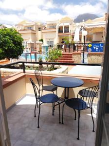 a patio with two chairs and a table on a balcony at Costa Adeje Fañabé Beach Apartment in Adeje