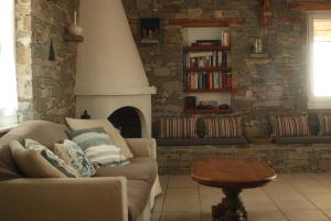 a living room with a couch and a fireplace at Kapari Home Syros in Vári