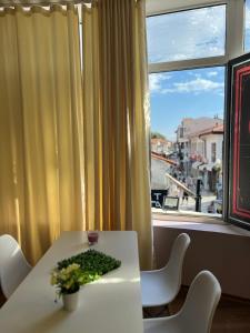 a table with a vase of flowers and a window at Villa Passage in Ohrid