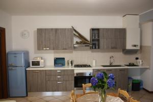 a kitchen with a table with a vase of purple flowers at Sotto la Rocca in Angera