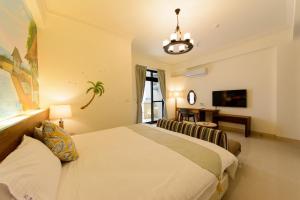 una camera da letto con un letto, un divano e una televisione di BeautyFlower Cottage a Ji'an