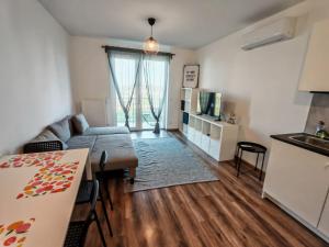 a living room with a couch and a table and a kitchen at Juniper Studio in Kecskemét