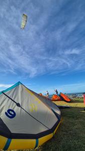 a group of people flying kites in a field at La Famiile in Icapuí