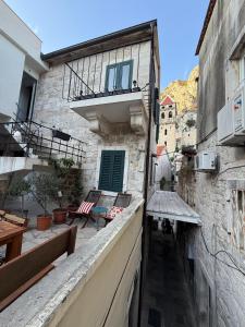 a building with a balcony with a table and chairs at Holiday home Teraca u Babe- in the town center in Omiš +30 photos
