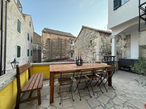 a wooden table and chairs on a patio at Holiday home Teraca u Babe- in the town center in Omiš