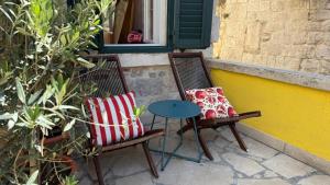 two chairs and a table in front of a window at Holiday home Teraca u Babe- in the town center in Omiš