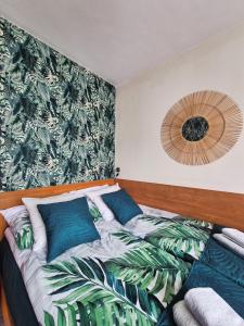 a bedroom with a bed with blue pillows at Kokosek Pokoje Gościnne in Mielno