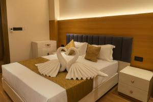 dois cisnes, representados como asas, estão em uma cama em Hotel Parth Inn by IQ Hotels-Best Hotel Near Ram Mandir Ayodhya em Ayodhya mais 19 fotografias