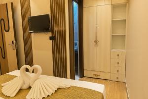 dois cisnes sentados numa cama num quarto em Hotel Parth Inn by IQ Hotels-Best Hotel Near Ram Mandir Ayodhya em Ayodhya