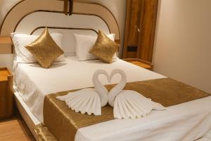 dois cisnes a fazer uma forma de coração numa cama em Hotel Parth Inn by IQ Hotels-Best Hotel Near Ram Mandir Ayodhya em Ayodhya