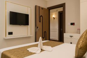 um quarto com uma cama e uma televisão na parede em Hotel Parth Inn by IQ Hotels-Best Hotel Near Ram Mandir Ayodhya em Ayodhya