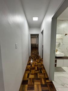 a hallway with wooden flooring in a house at Aconchegante apto no Centro! in Concordia
