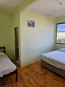 ウバジャラにあるCasa Mandacaruのベッド2台と窓のある寝室