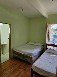 ウバジャラにあるCasa Mandacaruのベッドルーム1室(ベッド2台、シンク、窓付)