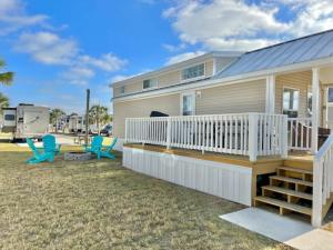 a manufactured home with a deck and chairs and a rv at Vacation Cottage North Myrtle Beach #66 in Myrtle Beach +11 photos