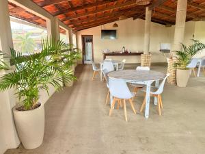 a patio with a table and chairs and plants at Pousada Viva Praia in Paracuru