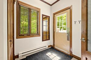 a hallway with a door and a window at Tremblant Prestige - Manoir 108-2 in Mont-Tremblant