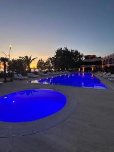 a large pool with blue water at dusk at Grand Vuslat Erdek in Erdek