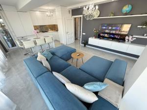 a living room with a blue couch and a kitchen at RentNow Large and Cozy Apartment in the Center, Parking in Chişinău