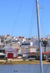 a boat in the water with buildings in the background at Cabines Catamaran Breakfast-Brunch Included, Optional Lunch & Dinner in Alvor