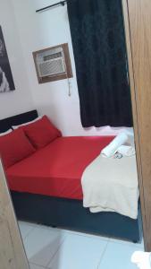 een kleine kamer met een rood bed en een raam bij Centro, Maracanã, rodoviaria perto, SmarTV, vista fantástica in Rio de Janeiro