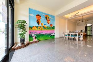 una sala da pranzo con un grande dipinto di mongolfiere di BeautyFlower Cottage a Ji'an