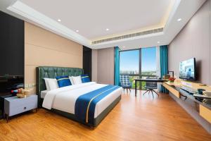 a bedroom with a bed and a desk and a television at Weekend International Apartment- Beijing Rd A-mall in Guangzhou