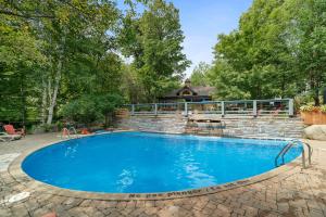 a swimming pool with a brick retaining wall and a stone wall at Tremblant Prestige - Manoir 108-2 in Mont-Tremblant +23 photos
