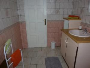 a bathroom with a sink and a white door at Appartement familial à Saint-Esprit, 95m² avec terrasse in Quartier Palmène +3 photos