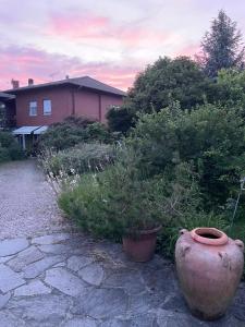 a large vase sitting in a yard with plants at B&B Villa Giardini Susanna in Veruno