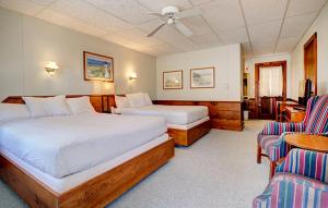 a hotel room with two beds and a table and chairs at The Holiday House Inn & Motel in Scarborough