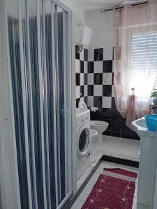 a bathroom with a washing machine in a washer at casa meloni in Terralba +2 photos