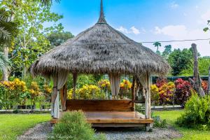 a wooden gazebo with a grass roof at Saranghae Chiang Dao in Chiang Dao