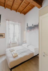 a bedroom with a large white bed with two towels on it at 21 Duomo - Camera con bagno privato in Florence