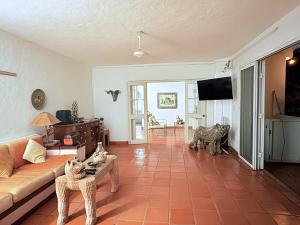 a living room with a couch and a table at Casa Basea in Zihuatanejo