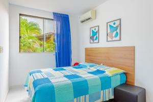 a bedroom with a blue and white bed and a window at IT107 Apto Pé na Areia com com 3/4 - Itacimirim in Itacimirim +27 photos