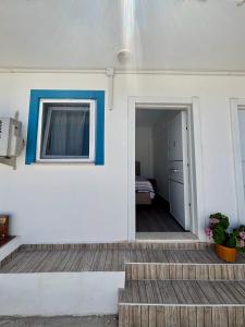 a white house with a blue trim and stairs at Huzur Pansiyon in Çanakkale