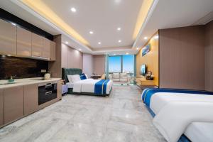 a hotel room with two beds and a kitchen at Weekend International Apartment- Beijing Rd A-mall in Guangzhou