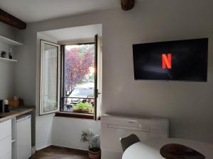 Alloggio turistico All'Ombra della Torre في فِتيربو: مطبخ مع تلفزيون مع N على الحائط