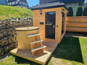 una dependance in legno con una scala su un ponte di Domek Góralski Niedźwiedzia Gawra & Sauna Zone by RentiloPL a Poronin