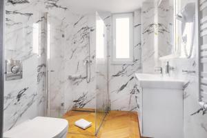 a white bathroom with a toilet and a sink at BELMAR Park Resort in Władysławowo