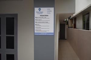 a sign on the side of a building with a hallway at FlexTays Campus - Budget Student Stays in Trivandrum +10 photos