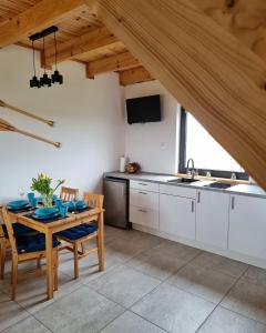 a kitchen with a table and chairs in a room at Baltic Sea- domki z jacuzzi blisko natury in Władysławowo