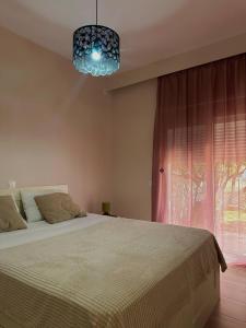a bedroom with a large bed and a window at Ledjon apartament in Artemida
