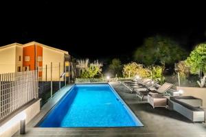 a swimming pool with lounge chairs next to a building at Cerchia Apartments in Corbara