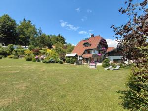 a large yard with a house with a red roof at Apartma Alpski vrt in Vojsko