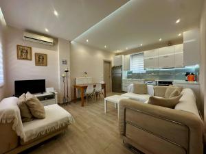 a living room with two couches and a kitchen at Ledjon apartament in Artemida