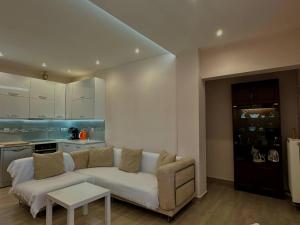 a living room with a white couch and a table at Ledjon apartament in Artemida