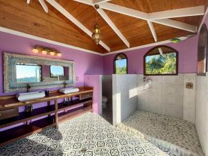 Playa HermosaUvita-ocean Views-large Pool-great Patio的紫色浴室设有两个盥洗盆和淋浴