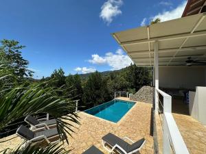 Playa HermosaUvita-ocean Views-large Pool-great Patio的房屋旁带椅子的游泳池